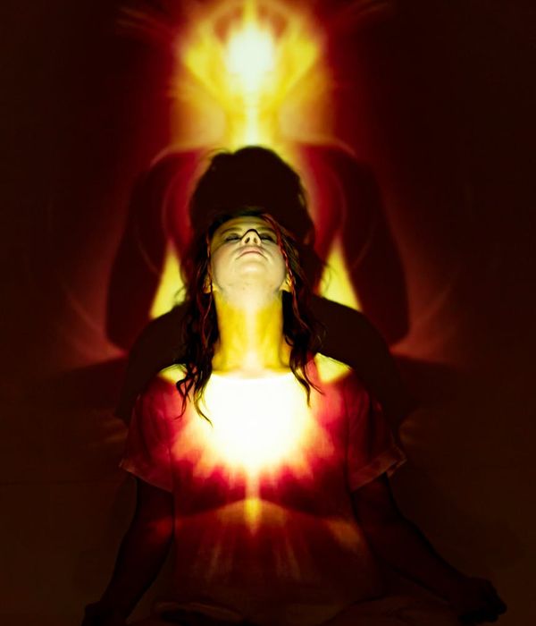 Woman in a flowing yoga pose with tangerine light accents.